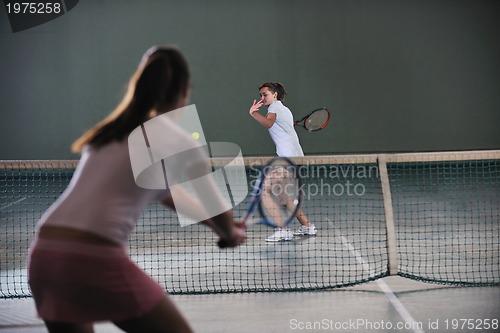 Image of young girls playing tennis game indoor