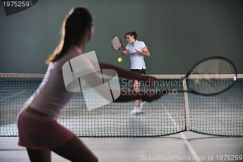 Image of young girls playing tennis game indoor