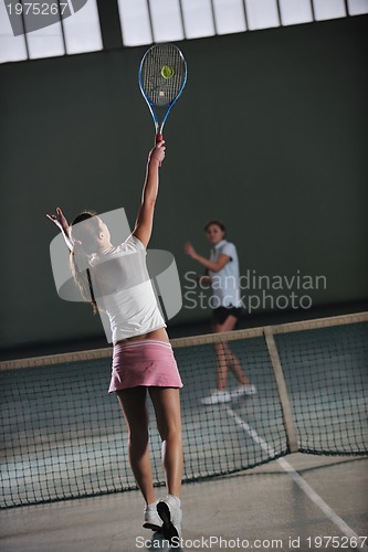 Image of young girls playing tennis game indoor