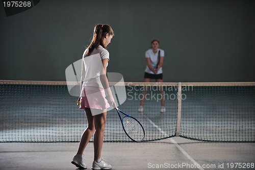 Image of young girls playing tennis game indoor
