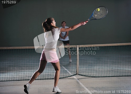 Image of young girls playing tennis game indoor