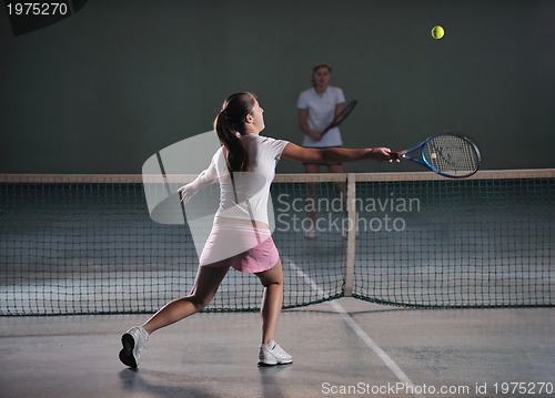 Image of young girls playing tennis game indoor