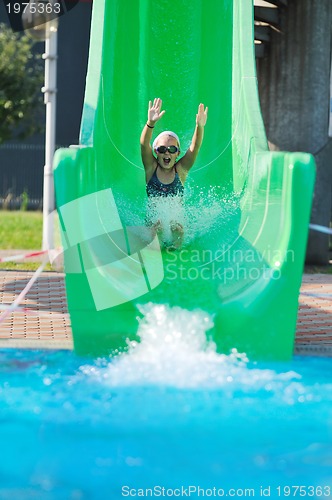 Image of girl have fun  on water slide at outdoor swimming pool