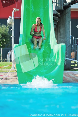 Image of girl have fun  on water slide at outdoor swimming pool