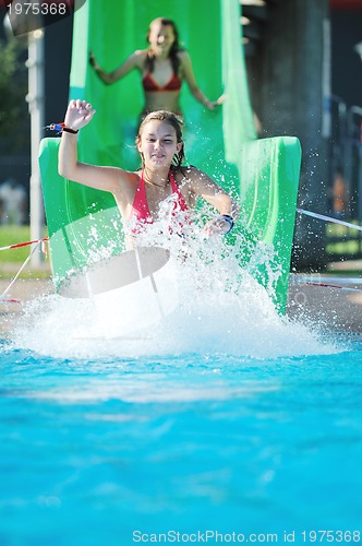 Image of girl have fun  on water slide at outdoor swimming pool