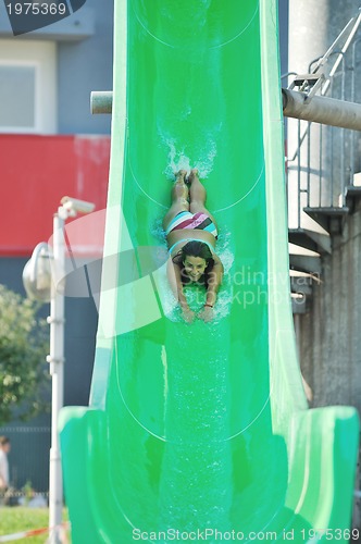 Image of girl have fun  on water slide at outdoor swimming pool