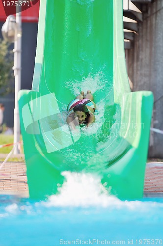 Image of girl have fun  on water slide at outdoor swimming pool