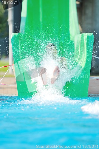 Image of girl have fun  on water slide at outdoor swimming pool