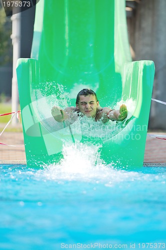 Image of girl have fun  on water slide at outdoor swimming pool