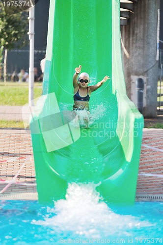 Image of girl have fun  on water slide at outdoor swimming pool