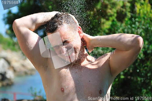 Image of young man relaxing under shower
