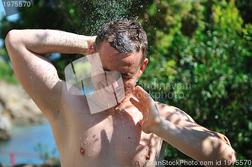 Image of young man relaxing under shower