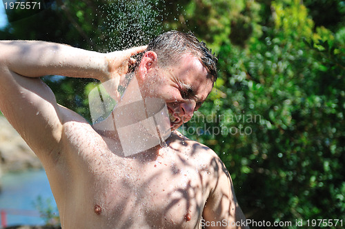 Image of young man relaxing under shower