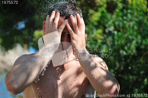 Image of young man relaxing under shower