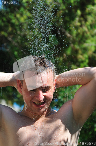 Image of young man relaxing under shower