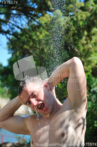 Image of young man relaxing under shower