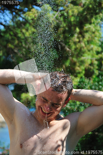 Image of young man relaxing under shower