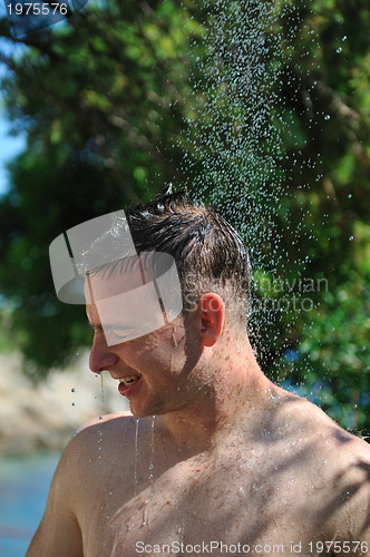 Image of young man relaxing under shower