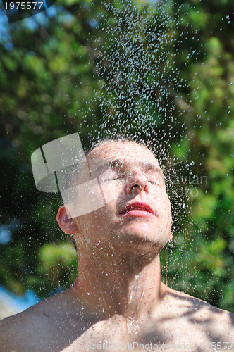 Image of young man relaxing under shower