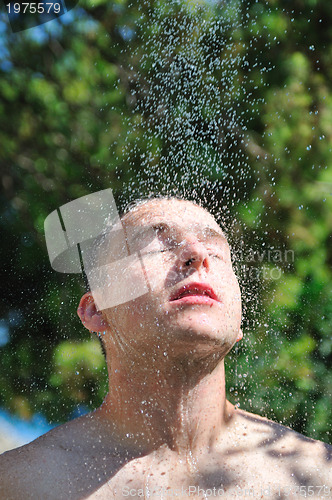 Image of young man relaxing under shower