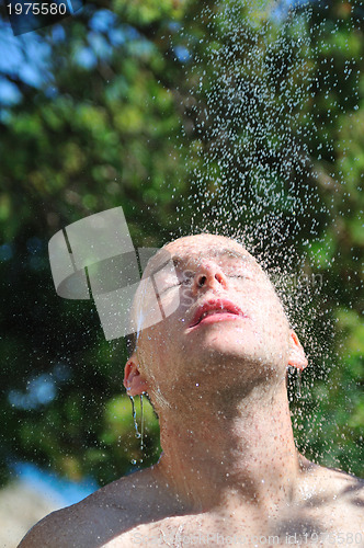 Image of young man relaxing under shower