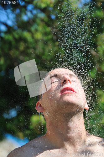Image of young man relaxing under shower