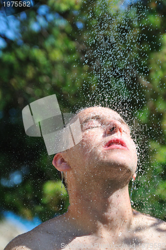 Image of young man relaxing under shower