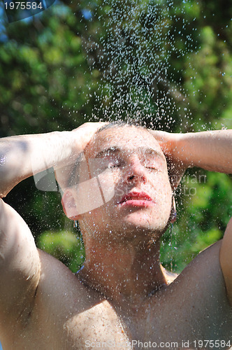 Image of young man relaxing under shower