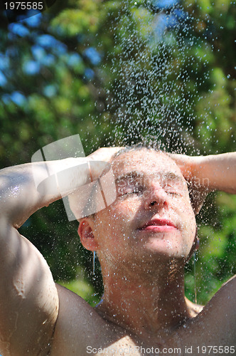 Image of young man relaxing under shower