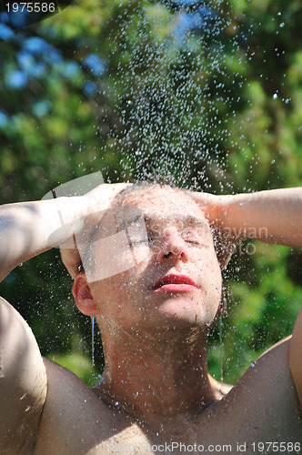 Image of young man relaxing under shower