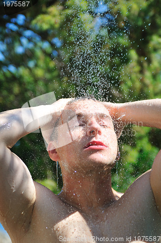 Image of young man relaxing under shower