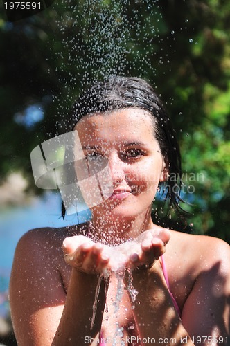 Image of beautiful woman washing and cleaning face under shower