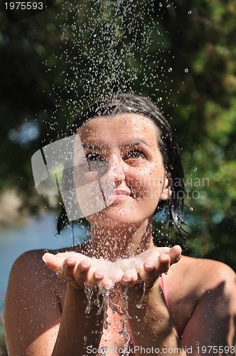 Image of beautiful woman washing and cleaning face under shower