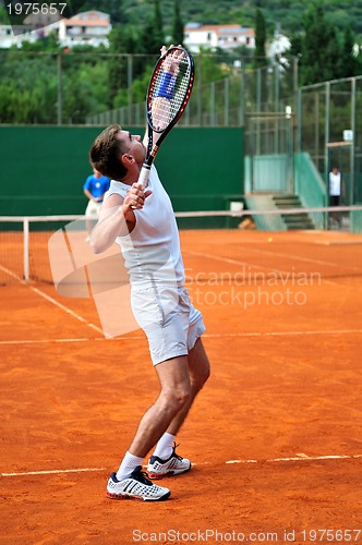 Image of Man plays tennis outdoors