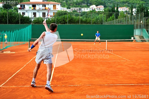 Image of Man plays tennis outdoors