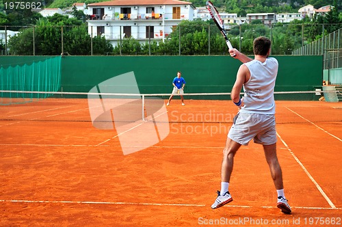 Image of Man plays tennis outdoors