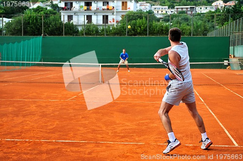 Image of Man plays tennis outdoors