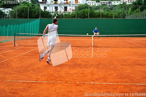 Image of Man plays tennis outdoors