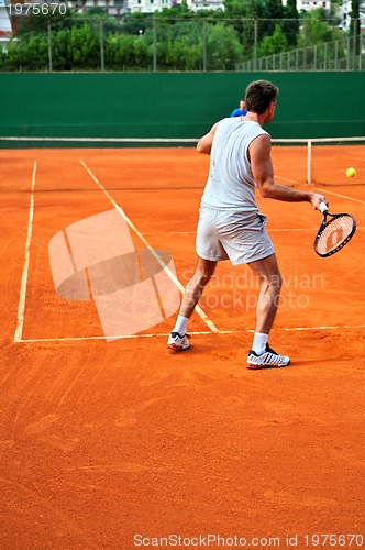 Image of Man plays tennis outdoors