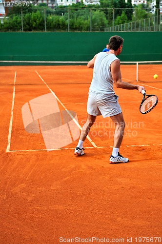 Image of Man plays tennis outdoors