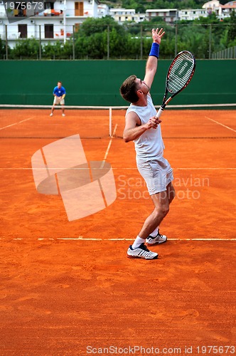 Image of Man plays tennis outdoors