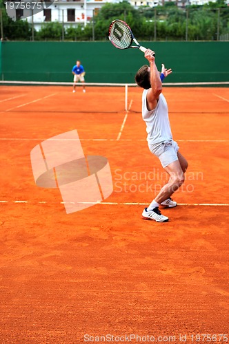 Image of Man plays tennis outdoors