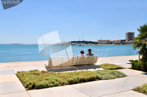 Image of Happy young couple sitting on the beach