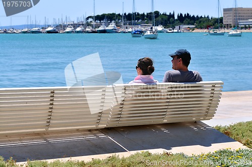 Image of Happy young couple sitting on the beach