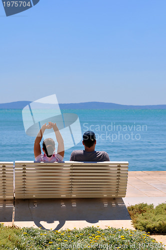 Image of Happy young couple sitting on the beach