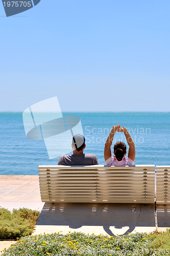 Image of Happy young couple sitting on the beach