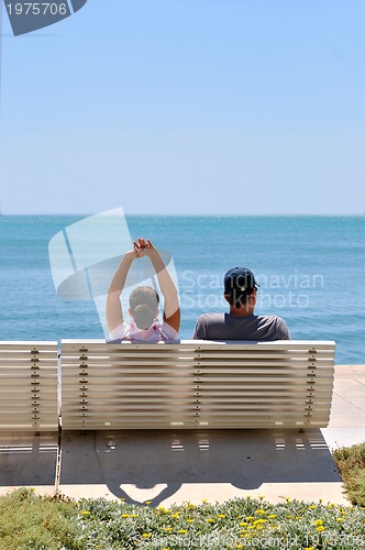 Image of Happy young couple sitting on the beach