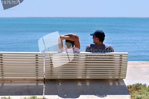 Image of Happy young couple sitting on the beach