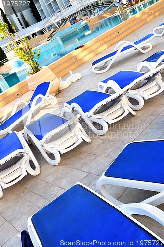 Image of Empty chairs by the pool of  hotel