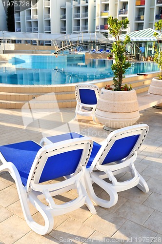 Image of Empty chairs by the pool of  hotel